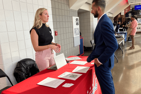Employer speaking with a candidate at a career fair booth
