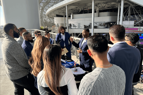 Group of attendees gathered around a booth at the LA Chargers career fair