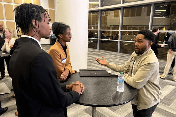 Attendees networking at a table during an Atlanta Hawks career event