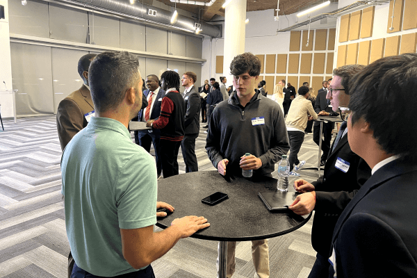 Attendees networking around a high-top table at an Atlanta Hawks career event